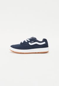 Marineblå semsket sneakers med hvite detaljer, snøring, og en polstret hvit mellomsåle. Har en gummigummisåle.