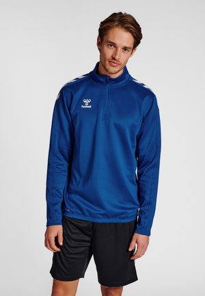 Blauwe sportieve pullover met een half-rits ontwerp, voorzien van witte strepen op de schouders en een logo op de borst. Lichtgewicht stof.