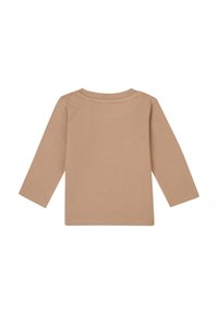 Chemise à manches longues en coton beige clair avec un col rond et des ourlets cousus, présentant une texture lisse et un design simple.
