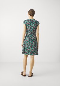 Zielona sukienka z krótkim rękawem, z kwiatowym wzorem w odcieniach różu i beżu. Dopasowany gorset, rozkloszowana spódnica i długość do kolan. Udekorowana guzikami.