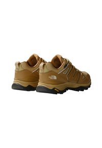 Brune turistsko sko med en teksturert overflate, som har pustende mesh og syntetiske detaljer. Vibram såle for grep, logo vises.