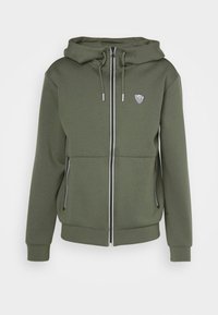 Felpa con zip verde oliva in morbido materiale felpato, dotata di cappuccio, stringhe, tasche frontali e un patch con logo sul petto.