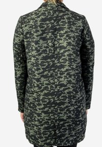 Abrigo de lana con estampado negro y verde, de silueta larga, hecho de tejido texturizado con cuello de solapa, abertura trasera y bolsillos laterales.