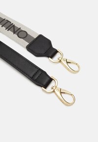 Svart syntetrem med guldfärgad hårdvara, med ett ljusgrått vävt band med "Valentino"-text. Klippfästen möjliggör mångsidig användning.