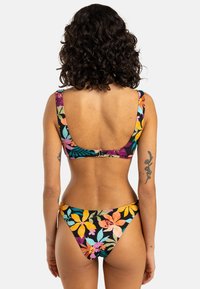 Blommigt bikiniset med svart bakgrund och färgglada tropiska mönster. Toppen har breda axelband och byxorna är låg midja.
