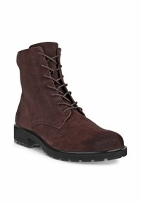 Brown suede ankle boot with a rounded toe, lace-up front, and rubber outsole. Features a textured upper and reinforced stitching details.