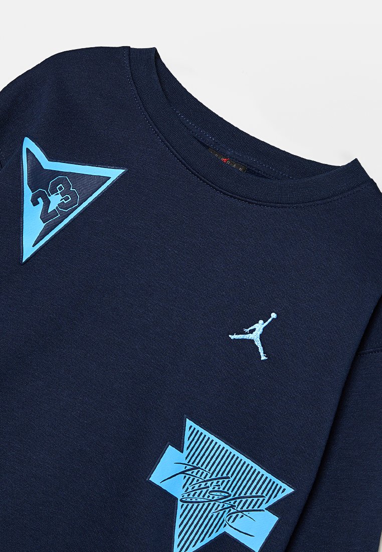Granatowy sweatshirt z niebieskimi akcentami, z logo i grafikami. Teksturowane łatki oraz prążkowany dekolt dopełniają wygląd.