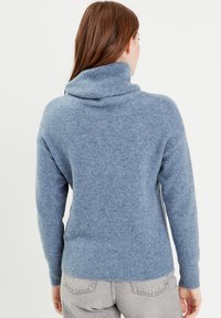 Cowl neck sweater in soft, blue knit fabric. Features ribbed cuffs and hem, with dropped shoulders and a relaxed fit.