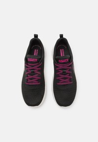 Scarpe da ginnastica nere con una tomaia in rete traspirante, lacci rosa e suola bianca. Presentano un logo sulla linguetta e un motivo testurizzato sulla tomaia.