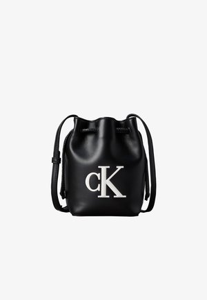Sac seau en cuir noir avec cordon de serrage en haut et logo blanc "cK" sur le devant, doté d’une bandoulière réglable.