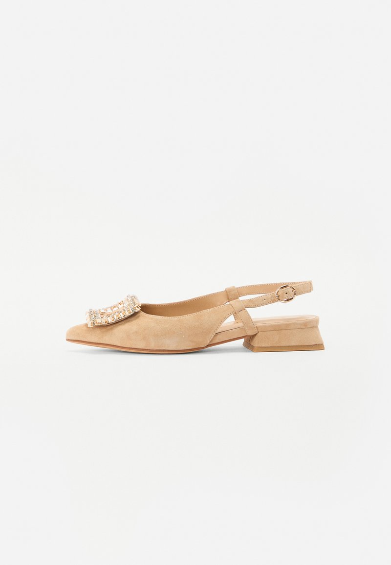 Chaussure à talon slingback en suede beige avec un bout pointu, ornée d'une boucle décorative accentuée de cristaux et d'un petit talon carré.