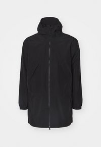 Zwarte waterdichte jacket met een capuchon, lange mouwen, een ritssluiting aan de voorkant en twee grote zijzakken. Glad van textuur en eenvoudig ontwerp.