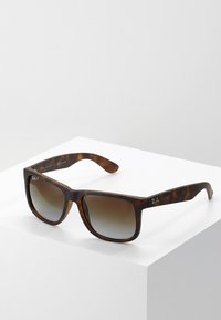 Ochelari de soare Ray-Ban cu ramă din scoică țestoasă, formă pătrată, lentile degrade maro și logo gravat pe braț.