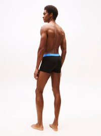 Boxer briefs neri con una cintura blu che presenta un logo, mostrati su un modello maschile su uno sfondo neutro, che evidenziano un design aderente.