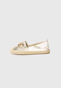 Kultaiset metalliset espadrille-kengät, joissa on juuttipohja, koristeellinen kultainen solki ja tasainen muotoilu. Sujuva pinta.
