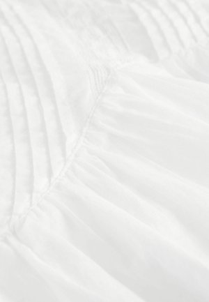 Valge kangas, millel on voldid ja kogutud osad, esitleb pehmet, kerget tekstuuri, millel on sile viimistlus ja õrn sära.