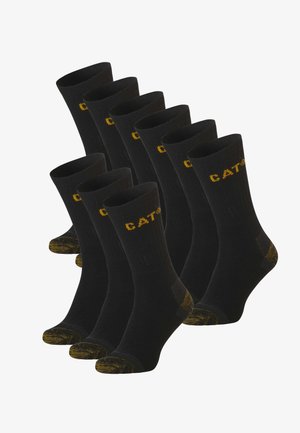 Black cotton socks set with yellow CAT logo. Ribbed texture, reinforced heel and toe, and patterned accents at the cuff.