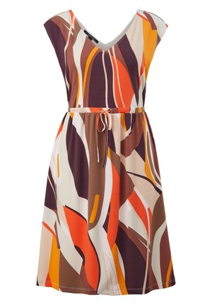 Femme portant une robe sans manches longueur genou avec un motif abstrait orange, marron et crème, taille marquée par un lien et sandales plates beiges.