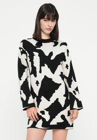 Zwart-wit gemêleerde trui jurk met een losse fit, lange mouwen, ronde halslijn en een zachte, gestructureerde brei stof.