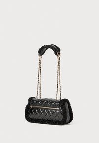 Borsa a mano nera trapuntata con dettagli in pelliccia sintetica, tracolle in catena dorata e un compartimento con zip. Forma rettangolare con superfici testurizzate.
