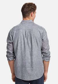 Camicia button-up a righe blu e bianche con maniche lunghe, colletto e cucitura sulla spalla posteriore. Il tessuto sembra leggero e ha una consistenza morbida.
