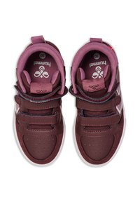 Vinröda sneakers med förstärkt läder, kardborreband och vadderad krage. Har vita accenter och perforerat läder för andningsförmåga.