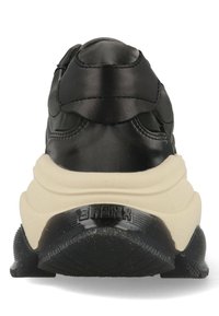 Zwarte leren sneaker met een dikke crèmekleurige tussenzool, afgeronde vorm, gestructureerde rubberen buitenzool en merkdetail op de hiel.