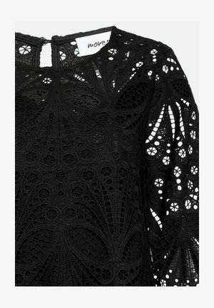 Zwarte kant top met ingewikkelde, gelaagde patronen en uitsnijdingen, met lange mouwen en een sluiting met sleutelgat aan de achterkant.