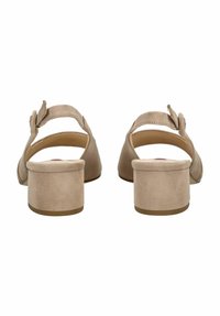 Sandalias de ante beige con tira al tobillo y tacón cuadrado. Presentan una textura suave y una hebilla ajustable única para un ajuste seguro.