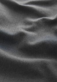 Material de culoare gri închis, cu o textură netedă, prezentând pliuri și cute delicate. Țesătura este strânsă și consistentă, punând în evidență un luciu subtil.