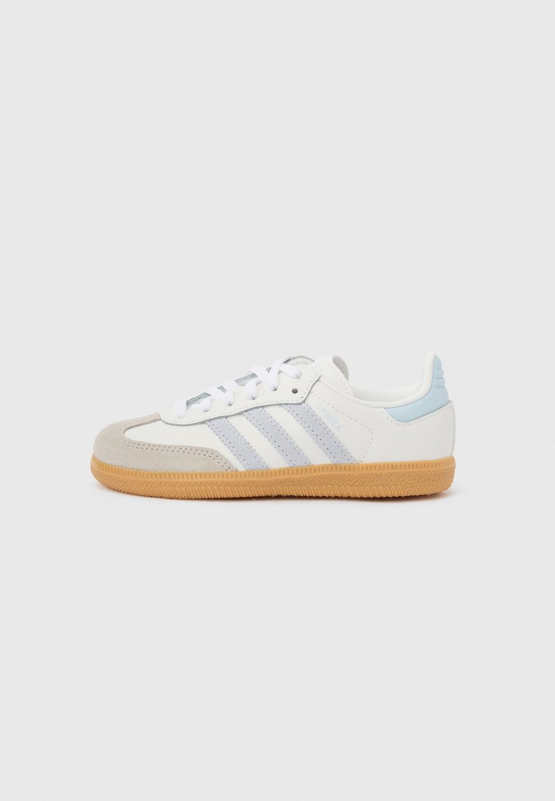 Adidași din piele întoarsă albă și gri cu accente bleu deschis, cu trei dungi bleu deschis, șireturi albe și talpă gumă.