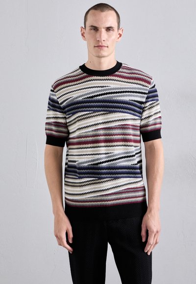 Kurze Ärmel Strickpullover mit wellenförmigem Muster in Creme, Marineblau, Rot und Schwarz. Gerippter Rundhalsausschnitt und Saum, strukturiertes Finish.
