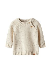 Pull en tricot couleur crème avec un tissu texturé, des poignets et un ourlet côtelés. Présente deux boutons en bois sur l'épaule gauche.