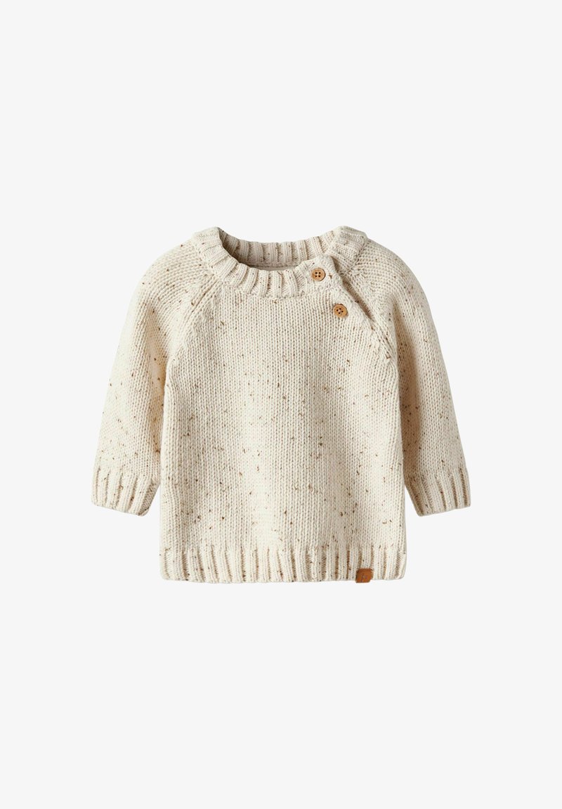 Pull en tricot couleur crème avec un tissu texturé, des poignets et un ourlet côtelés. Présente deux boutons en bois sur l'épaule gauche.