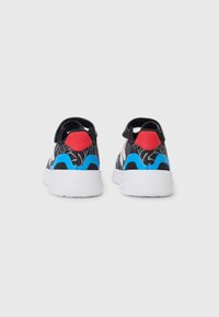 Sneakers neri con un motivo testurizzato, con accenti rossi e blu. Suola in gomma bianca e cinturino regolabile sul retro per maggiore supporto.