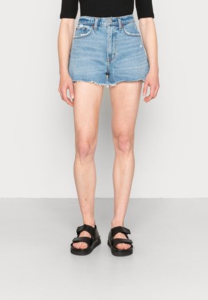 Shorts in denim azzurro chiaro, con orlo sfrangiato, vita alta e design a cinque tasche. Indossati con sandali neri piatti.