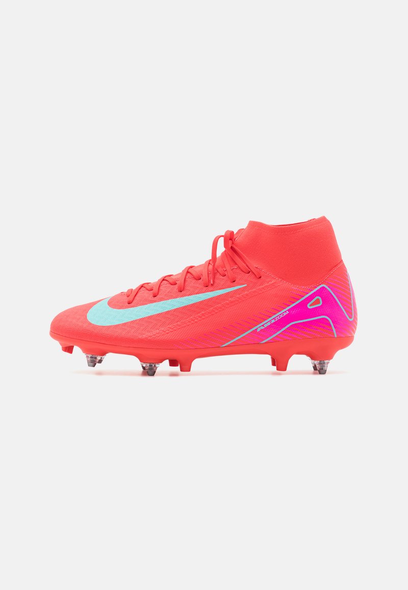 Cizma de fotbal roșie cu un upper texturat, swoosh Nike de culoare albastru deschis în contrast, guler înalt și puncte vizibile pentru tracțiune pe talpă.