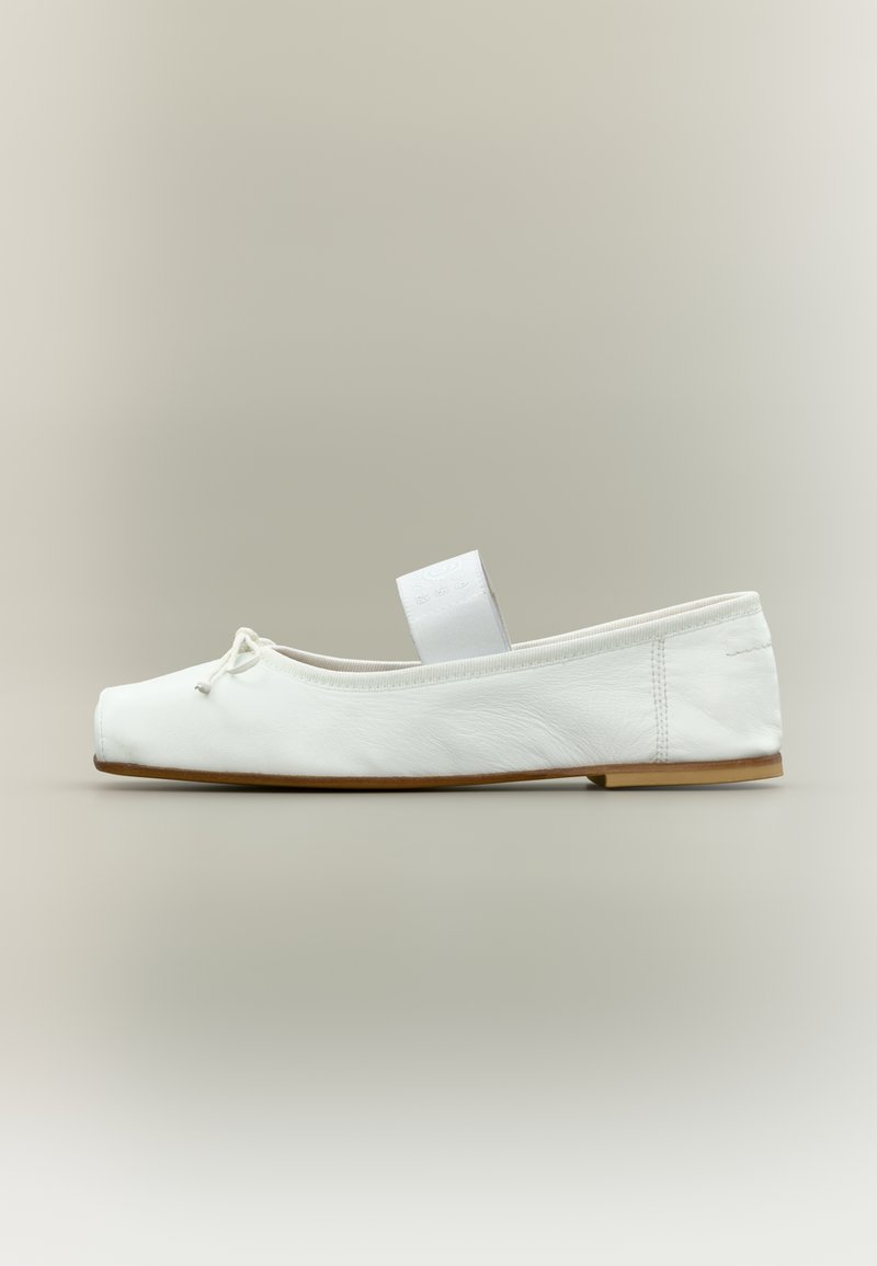 Ballerine blanche à bout carré, dessus en cuir souple, semelle plate, petit nœud à l'avant et large bande élastique sur le coup de pied.