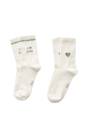 Weiße Baumwollsocken mit grünem Text "I ❤️ LDN" und einem kleinen grünen Herzen. Gerippte Textur am oberen Ende. Verstärkte Zehen- und Fersenpartie.