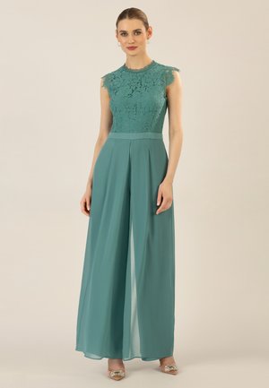 Teal jumpsuit featuring a lace bodice, cap sleeves, and wide-legged trousers with pleats. Elegant design with a smooth flowing fabric.