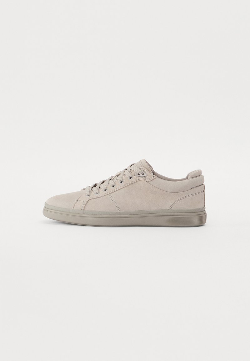Light gray suede sneaker with sleek design, round toe, and flat rubber sole. Features tonal laces and minimalist stitching details.