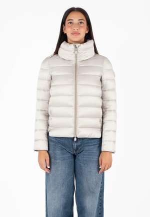 Giacca a vento grigia chiara con colletto alto, chiusura con zip e design a righe orizzontali. Indossata sopra jeans a gamba larga blu, con una texture morbida.