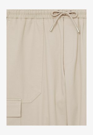 Beige cargobroek heeft een tailleband met trekkoord, zijzak en een gladde, gestructureerde stof met subtiele stikseldetails.