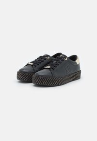 Czarne skórzane sneakersy z złotymi oczkami, z wplatanym wzorem w śródstopiu i kontrastującym beżowym akcentem na pięcie. Sznurowana konstrukcja.
