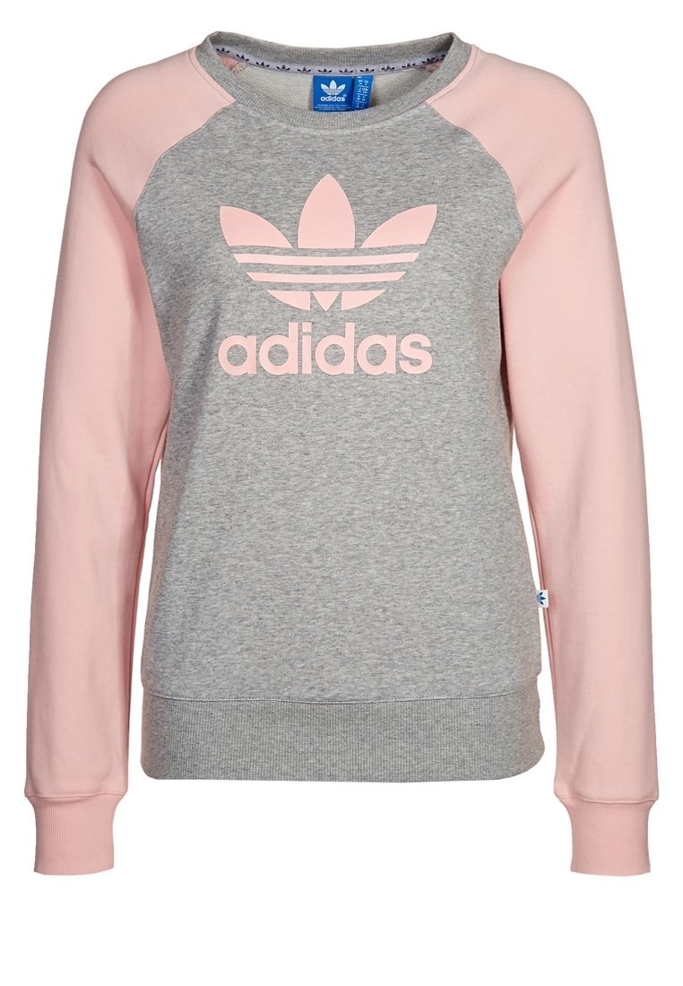 Ljusgrå sweatshirt med rosa raglanärmar. Har en stor rosa Adidas-logotyp på framsidan. Tillverkad av mjukt tyg med ribbade muddar.