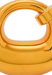 Gennemsigtig orange glasobjekt med en afrundet, glat form og et udskåret håndtag. Har en blank overflade og et minimalistisk design.