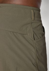 Olivenfargede shorts laget av lett stoff med en glatt tekstur, sidelommer og synlige sømmer.