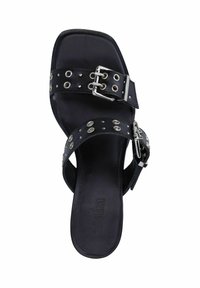 Sandale en cuir noir avec un bout carré, deux larges bandes ornées de clous en argent et d'une boucle, texture lisse et semelle plate.