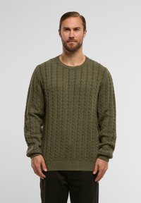 Oliwkowy sweter dzianinowy z wzorem w warkocze, okrągłym dekoltem oraz długimi rękawami z prążkowanymi mankietami i dołem. Miła w dotyku faktura i luźny krój.