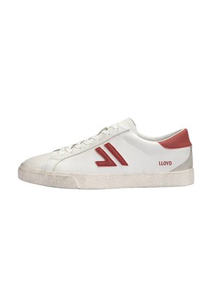 Baskets basses blanches avec des détails rouges, logo sur le côté, lacets à l’avant, et semelle texturée légèrement usée.